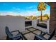 Relaxing outdoor patio features a modern fireplace, stylish seating, and travertine pavers with artificial turf at 3626 N Mohave Way, Scottsdale, AZ 85251
