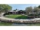 Exterior of the Ranch House community clubhouse surrounded by landscaping and a pond at 4073 E Stable Ct, Gilbert, AZ 85297