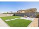Backyard with artificial turf, a paver patio, a stone fire pit, and block wall fencing at 4283 W Nora Dr, San Tan Valley, AZ 85144