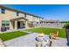 Large backyard featuring artificial turf, patio pavers, covered patio, BBQ, dining area, and modern firepit at 4283 W Nora Dr, San Tan Valley, AZ 85144
