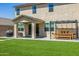 A spacious backyard featuring artificial turf, pavers, covered patio, pergola, dining area, and a barbecue at 4283 W Nora Dr, San Tan Valley, AZ 85144