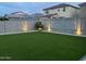 A lush green backyard features block wall fencing with garden lighting and decorative rocks at 4283 W Nora Dr, San Tan Valley, AZ 85144