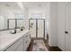 Well-lit bathroom showcasing double sinks, a sleek glass shower, and wood-look tile at 4283 W Nora Dr, San Tan Valley, AZ 85144