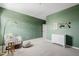 Cozy bedroom with green walls, chair, dresser, and desert themed artwork at 4283 W Nora Dr, San Tan Valley, AZ 85144