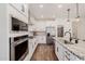 Open kitchen with stainless steel appliances, white cabinets, island, and walk-in pantry at 4283 W Nora Dr, San Tan Valley, AZ 85144