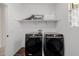 Bright laundry room features front load washer/dryer set, tile floor, and overhead shelving at 4283 W Nora Dr, San Tan Valley, AZ 85144