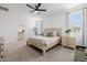 Airy main bedroom featuring a large bed, soft carpet, and large windows at 4283 W Nora Dr, San Tan Valley, AZ 85144