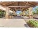 The covered patio has stone pillars, overhead lighting, and multiple tables and chairs at 4283 W Nora Dr, San Tan Valley, AZ 85144