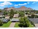 An aerial view showcasing the home, mature trees, and stunning mountain views beyond at 4510 E Calle Tuberia --, Phoenix, AZ 85018