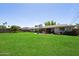 Expansive backyard featuring lush green grass, mature landscaping, and patio seating at 4510 E Calle Tuberia --, Phoenix, AZ 85018