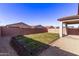 Well-maintained backyard featuring gravel, green grass, block wall and covered patio at 45722 W Sky Ln, Maricopa, AZ 85139