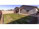 Manicured backyard with a strip of green grass, covered patio and window at 45722 W Sky Ln, Maricopa, AZ 85139