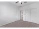 This bedroom offers neutral carpet, closet, and ceiling fan at 45722 W Sky Ln, Maricopa, AZ 85139
