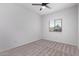 A bright bedroom features a neutral color palette, plush carpet, and a ceiling fan at 45722 W Sky Ln, Maricopa, AZ 85139