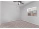 This bedroom features a ceiling fan, a window, and neutral carpet at 45722 W Sky Ln, Maricopa, AZ 85139