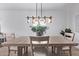 An elegant dining room featuring a wooden table and a modern chandelier at 45722 W Sky Ln, Maricopa, AZ 85139