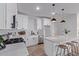 Well-lit kitchen with stainless steel appliances, white cabinets, and a central island with barstool seating at 45722 W Sky Ln, Maricopa, AZ 85139