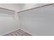 A well-organized walk-in closet with carpet, featuring white walls and wood shelving at 45722 W Sky Ln, Maricopa, AZ 85139