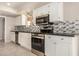 Modern kitchen with white cabinets, stainless steel appliances, and stylish backsplash at 529 E Taro Ln, Phoenix, AZ 85024