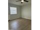 Bright bedroom featuring wood-look floors, a ceiling fan, and a window letting in natural light at 540 E Royal Palms Dr, Mesa, AZ 85203