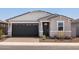 Charming single-story home featuring a dark garage door and decorative stone accents at 5549 S 246Th Ave, Buckeye, AZ 85326