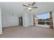 Bright living room features neutral carpet, large window, and sliding glass door at 5932 E Colby St, Mesa, AZ 85205