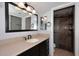 Bathroom features a vanity with sink, large mirror, lighting, and walk in shower at 6504 W Cochise Dr, Glendale, AZ 85302