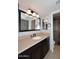 Bathroom features a vanity with sink, large mirror, lighting, and walk in shower at 6504 W Cochise Dr, Glendale, AZ 85302