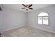 Empty bedroom featuring neutral walls, ceiling fan and an arched window at 6504 W Cochise Dr, Glendale, AZ 85302