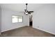 Bright bedroom features neutral walls, carpet and ceiling fan with bathroom access at 6504 W Cochise Dr, Glendale, AZ 85302