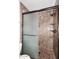 Elegant shower with glass door, bronze hardware, and stone wall and shelves at 6504 W Cochise Dr, Glendale, AZ 85302