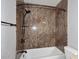 Close up of a shower tub combo with a shower head and toiletry shelves at 6504 W Cochise Dr, Glendale, AZ 85302