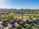 Wide aerial view showcases a community with lush golf course, and desert mountain backdrop at 654 E Taylor Trl, San Tan Valley, AZ 85143