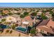 Aerial view showcases a home with a pool and covered patio in a sprawling desert neighborhood at 654 E Taylor Trl, San Tan Valley, AZ 85143