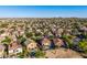 Aerial view of a home with a pool and covered patio in an extensive desert community at 654 E Taylor Trl, San Tan Valley, AZ 85143