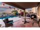 Covered back patio with outdoor seating overlooking a beautiful pool and landscaping at 654 E Taylor Trl, San Tan Valley, AZ 85143