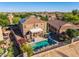 A backyard showcasing a fenced pool, covered patio, desert landscaping, and artificial putting green at 654 E Taylor Trl, San Tan Valley, AZ 85143