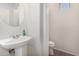Half bath featuring a pedestal sink, neutral tile floor, and modern fixtures at 654 E Taylor Trl, San Tan Valley, AZ 85143