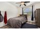 Comfortable bedroom featuring a ceiling fan, wood-look floors, and a large window at 654 E Taylor Trl, San Tan Valley, AZ 85143