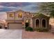 Attractive Southwestern home with arched windows, desert landscaping, and a two-car garage at 654 E Taylor Trl, San Tan Valley, AZ 85143