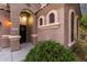 Close-up of front entryway showcasing arched windows, stone details, and lush landscaping at 654 E Taylor Trl, San Tan Valley, AZ 85143