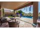 Covered patio with outdoor seating next to the backyard with views of the pool and manicured lawn at 654 E Taylor Trl, San Tan Valley, AZ 85143