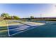 Multiple pickleball courts with blue and green surfaces, separated by black netting and fencing at 654 E Taylor Trl, San Tan Valley, AZ 85143