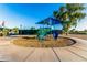Brightly colored playground under a blue canopy, surrounded by wood chips and a concrete walkway at 654 E Taylor Trl, San Tan Valley, AZ 85143