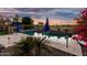 Backyard pool featuring a calming blue water, tiled surround, umbrellas, and views of the golf course at 654 E Taylor Trl, San Tan Valley, AZ 85143