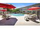Relaxing poolside area with lounge chairs, and red umbrellas, providing a resort-like atmosphere for residents at 6906 E 4Th St # 4, Scottsdale, AZ 85251