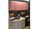 This laundry room features a washer, dryer, cabinets, and shelves at 717 W Lynwood St, Phoenix, AZ 85007