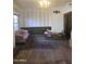 Bright living room with hardwood floors, vintage sofa, built-in shelving, and natural light from a large window at 717 W Lynwood St, Phoenix, AZ 85007