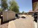 View of a fenced backyard with a shed, inground pool, fire pit, brick patio and plenty of shade at 723 W Milada Dr, Phoenix, AZ 85041