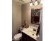 Well-lit powder room features a decorative mirror, vanity with sink and a toilet at 723 W Milada Dr, Phoenix, AZ 85041